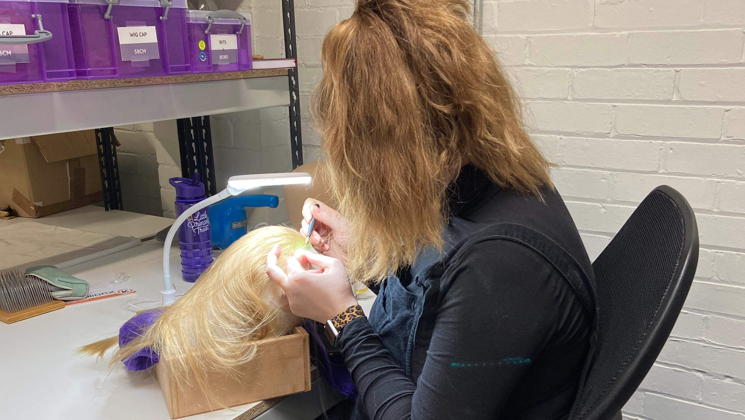 This is Holly knotting a wig at The Little Princess Trust
